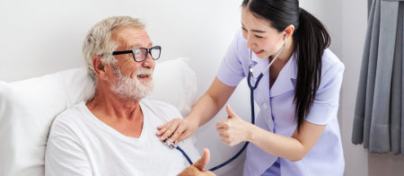 a nurse checking the blood pressure of a seniorm an