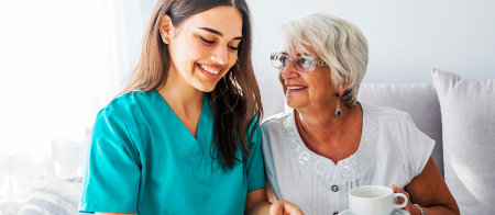 a caregiver and a senior woman reading