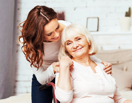 a caregiver and a senior woman looking at an album