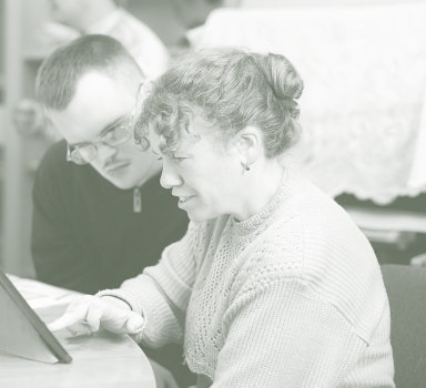 two people with mental disability watching on a mobile tablet