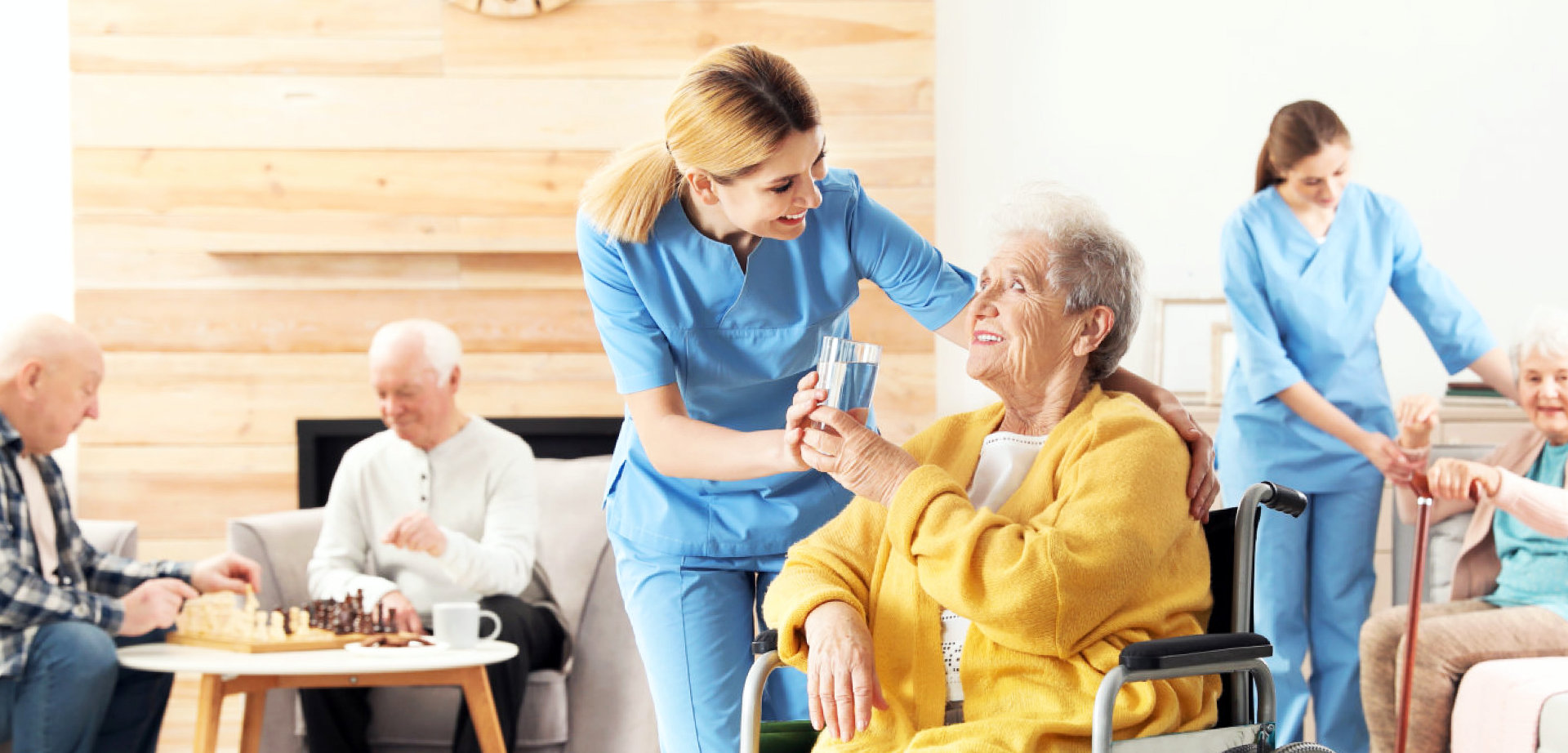 a caregiver giving water to a senior woman