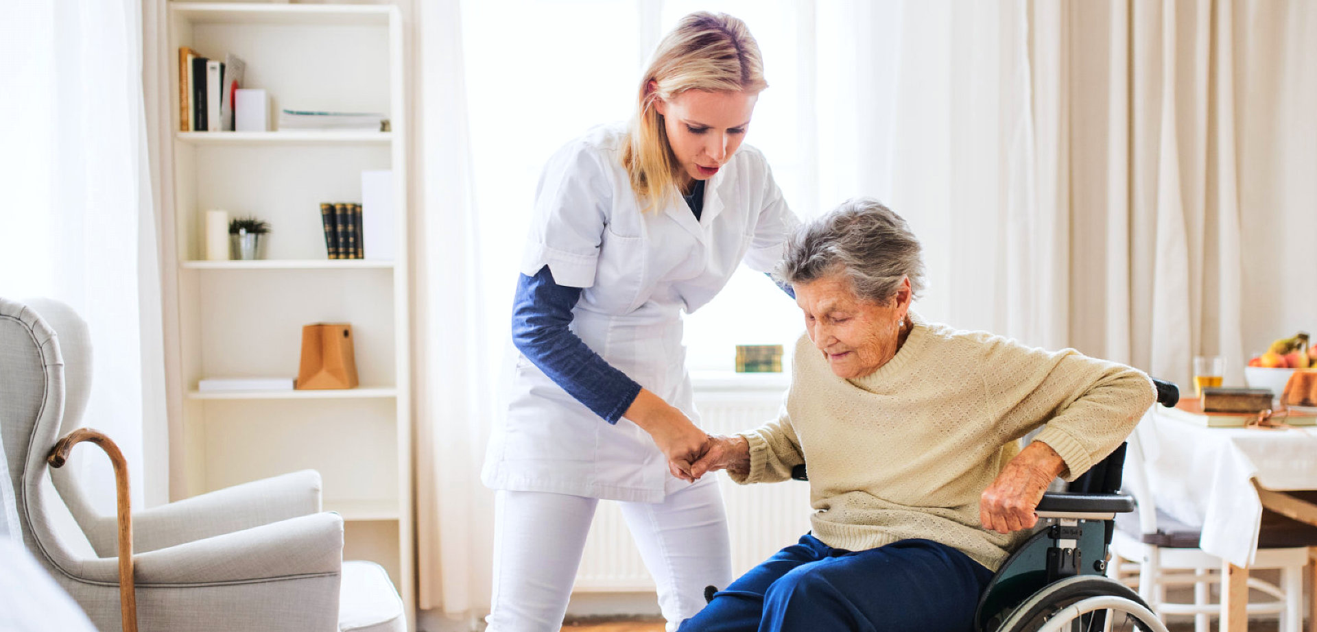 a caregiver helping a senior woman stand