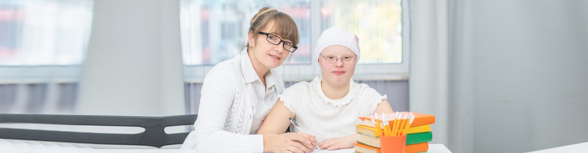 a caregiver helping a disabled child learn